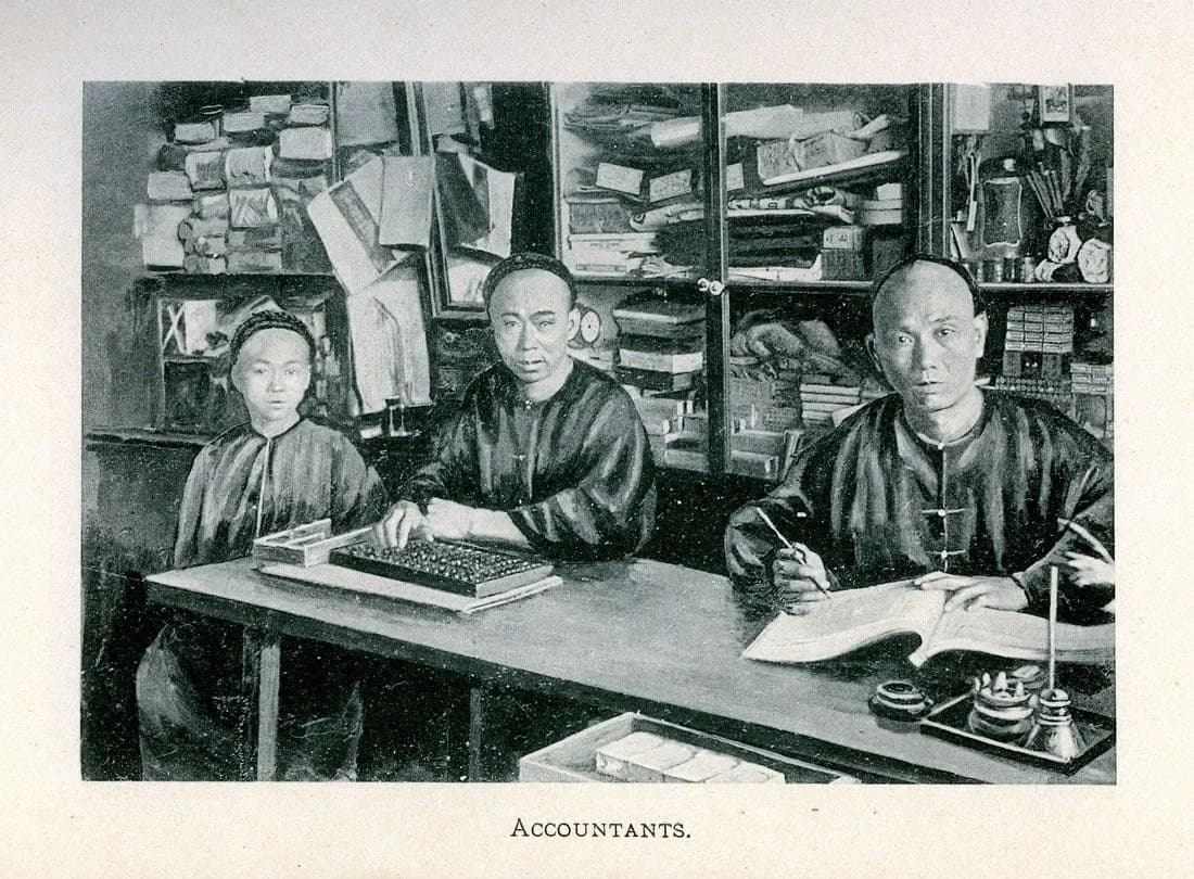 An 1892 archival photograph of Chinese accountants with an abacus in their San Francisco store.