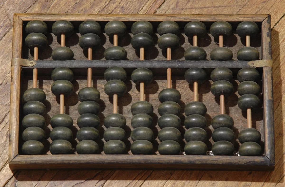 Close view of a traditional wooden Chinese Suanpan and its central beam.